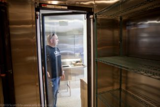 Alec showing the new custom built, walk-in refrigerator.