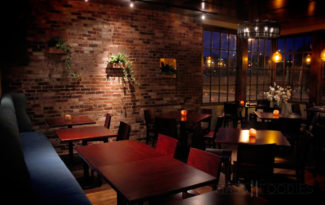 The exposed brick of the Lock 50 dining room compliments the window view overlooking Water Street in Worcester, MA