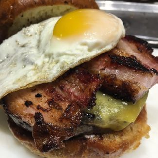 Local Burger begins with grass fed ground beef from Walnut Lane Farm, a Barndance Cheese from Robinson Farms, house cured Pork Belly made from Christian Hill Farm, and it's all topped with a local farm fresh egg and placed ever so gently on a Baker Bill Brioche Bun.