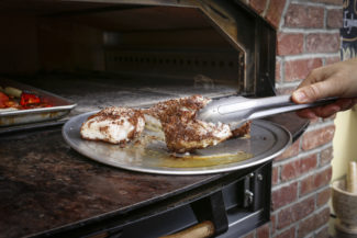 Atlantic cod with an anise crust being prepared in UXLocale's custom 900-degree oven.