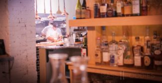 Executive Chef Jared Forman preparing meals while overlooking the dining room at deadhorse hill in Worcester, MA