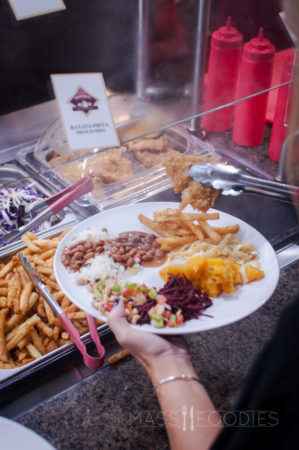 A diner choosing fried fish from the Terra Brasilis buffet on Shrewsbury Street in Worcester, MA.
