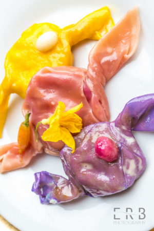 Tricolored Pierogi with miniature vegetable embellishments.