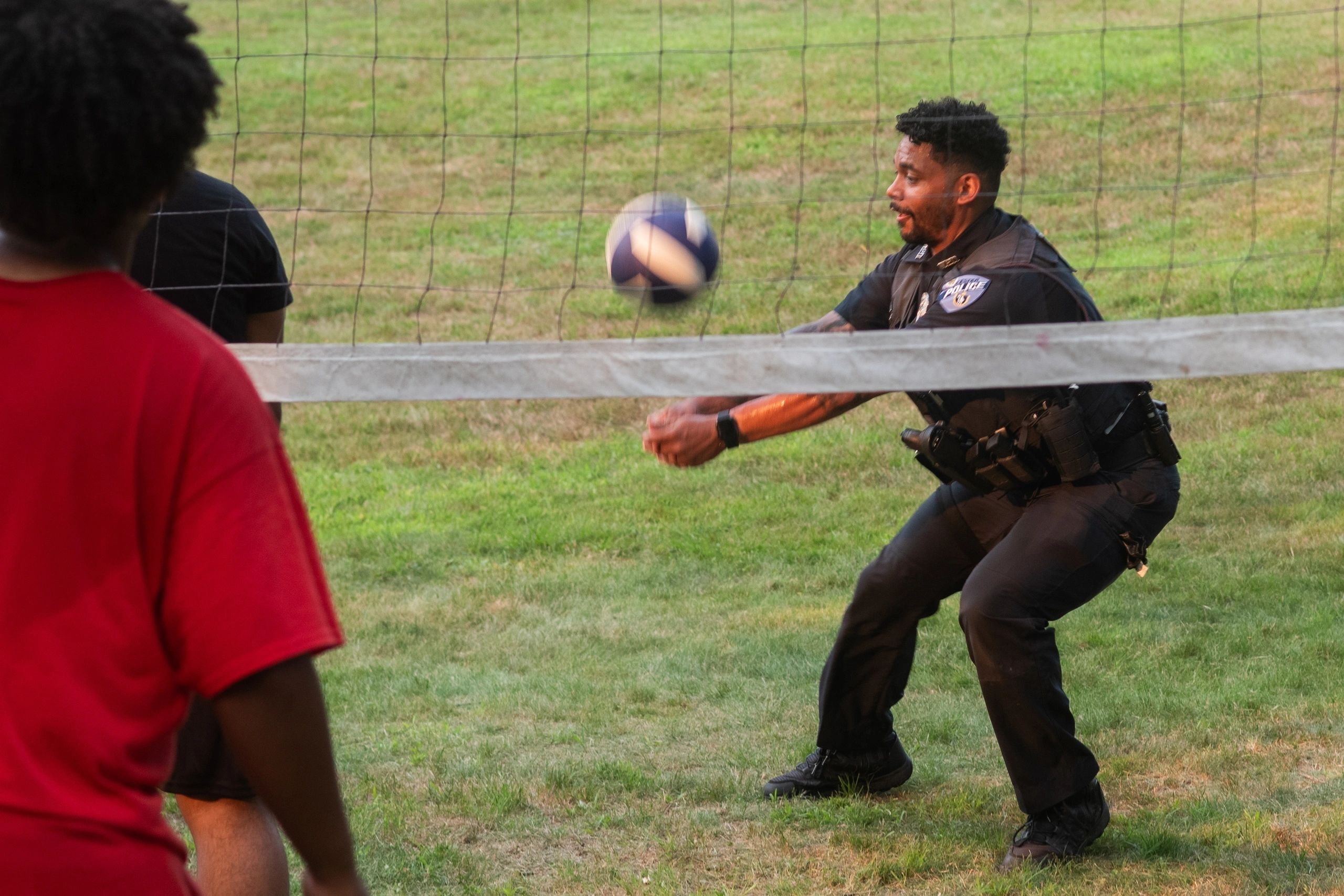 Officer Shawn Rozier plays volleyball with some young Worcester residents (photo by Steve Smith)