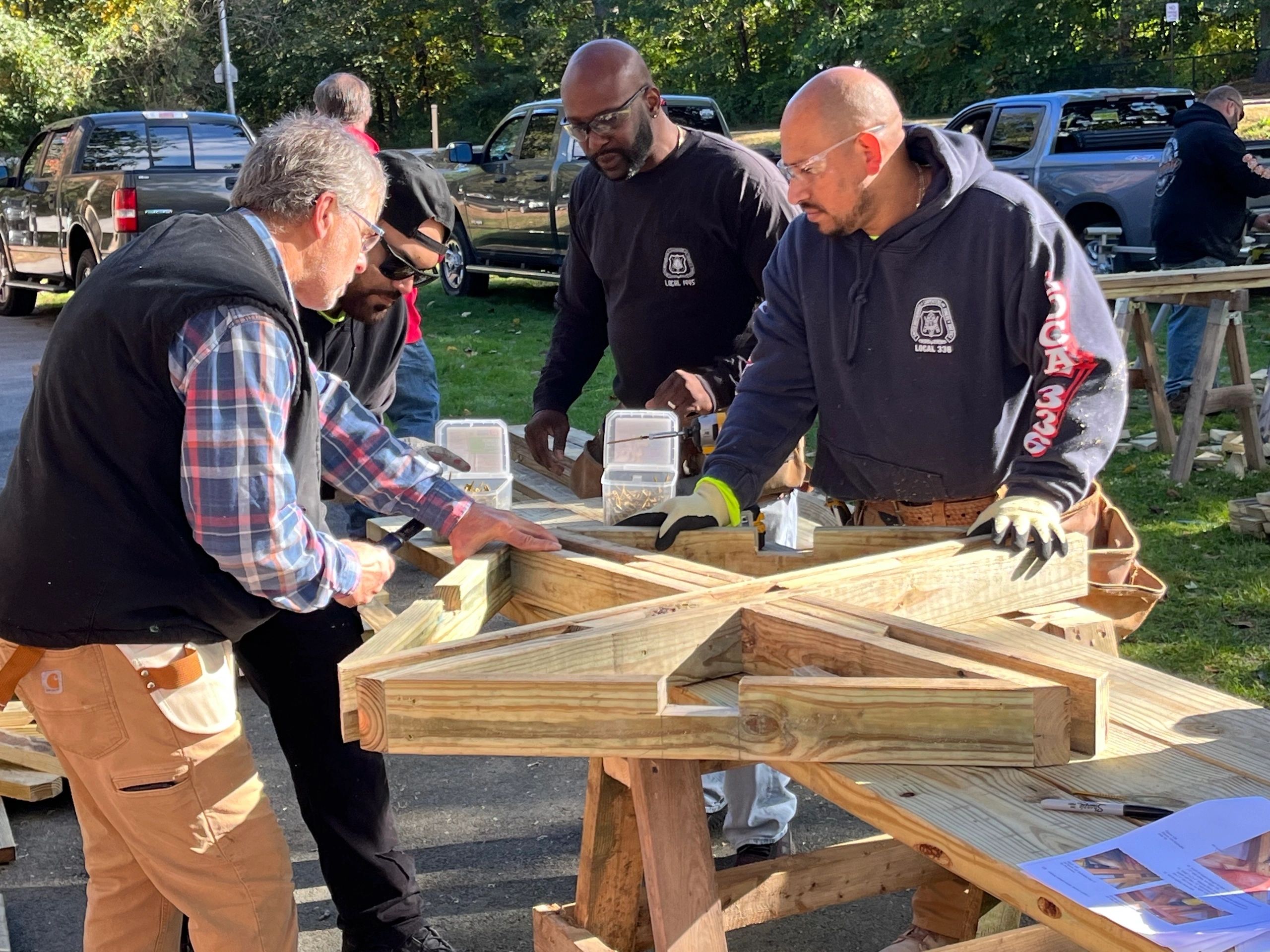 Members of Carpenters Union Local 366 work to construct a picnic table on Oct. 9