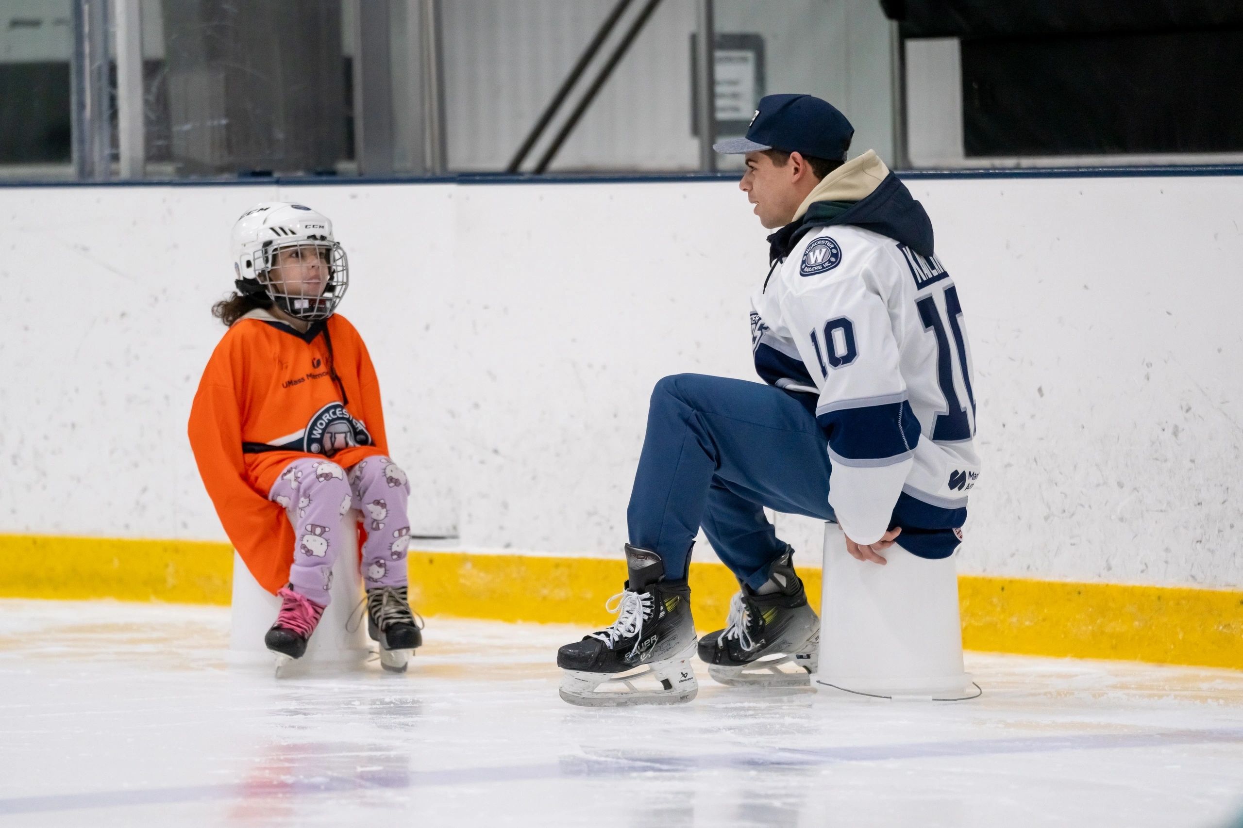 Jordan Kaplan with one of the visiting fourth graders this Tuesday at the Railers Skate to Success program (photo by Bill Ballou)
