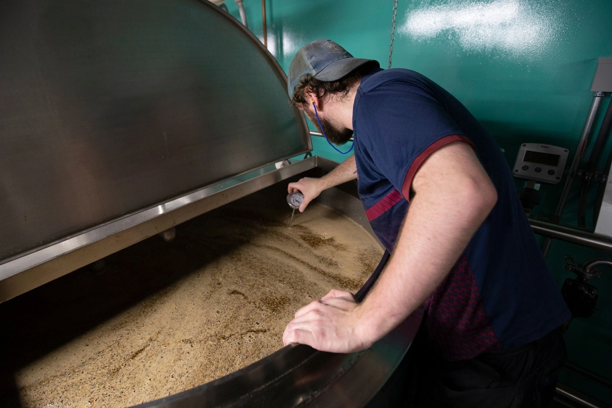 Greg Carlson checking the temperature of the mash (photo submitted))