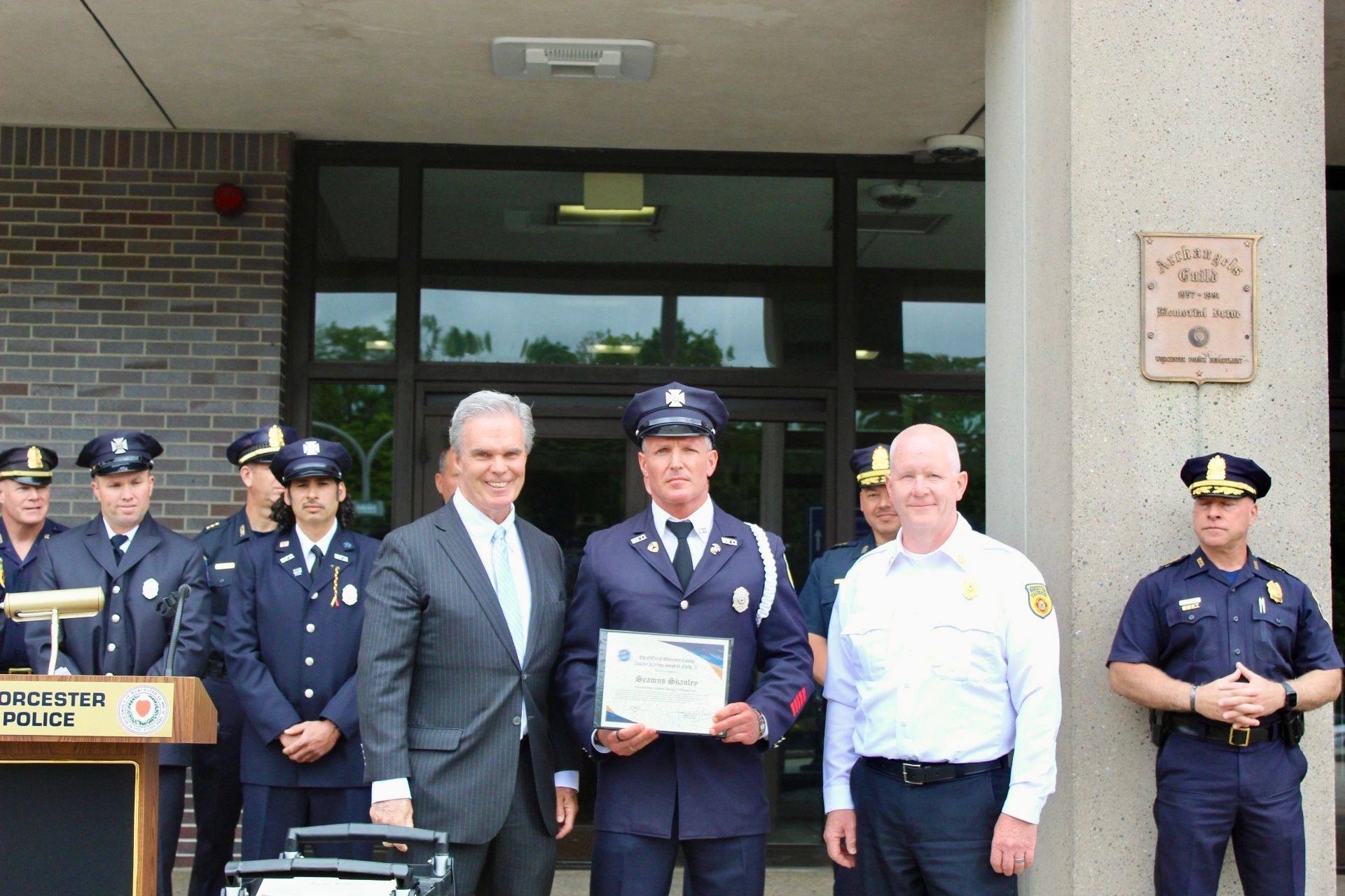 DA Joe Early and Worcester Police Chief Paul Saucier stands with officers and firefighters honored for rescuing residents from two simultaneous fires (photo courtesy)