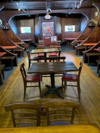 The wheel in the Ship Room with Bob Largess on left
