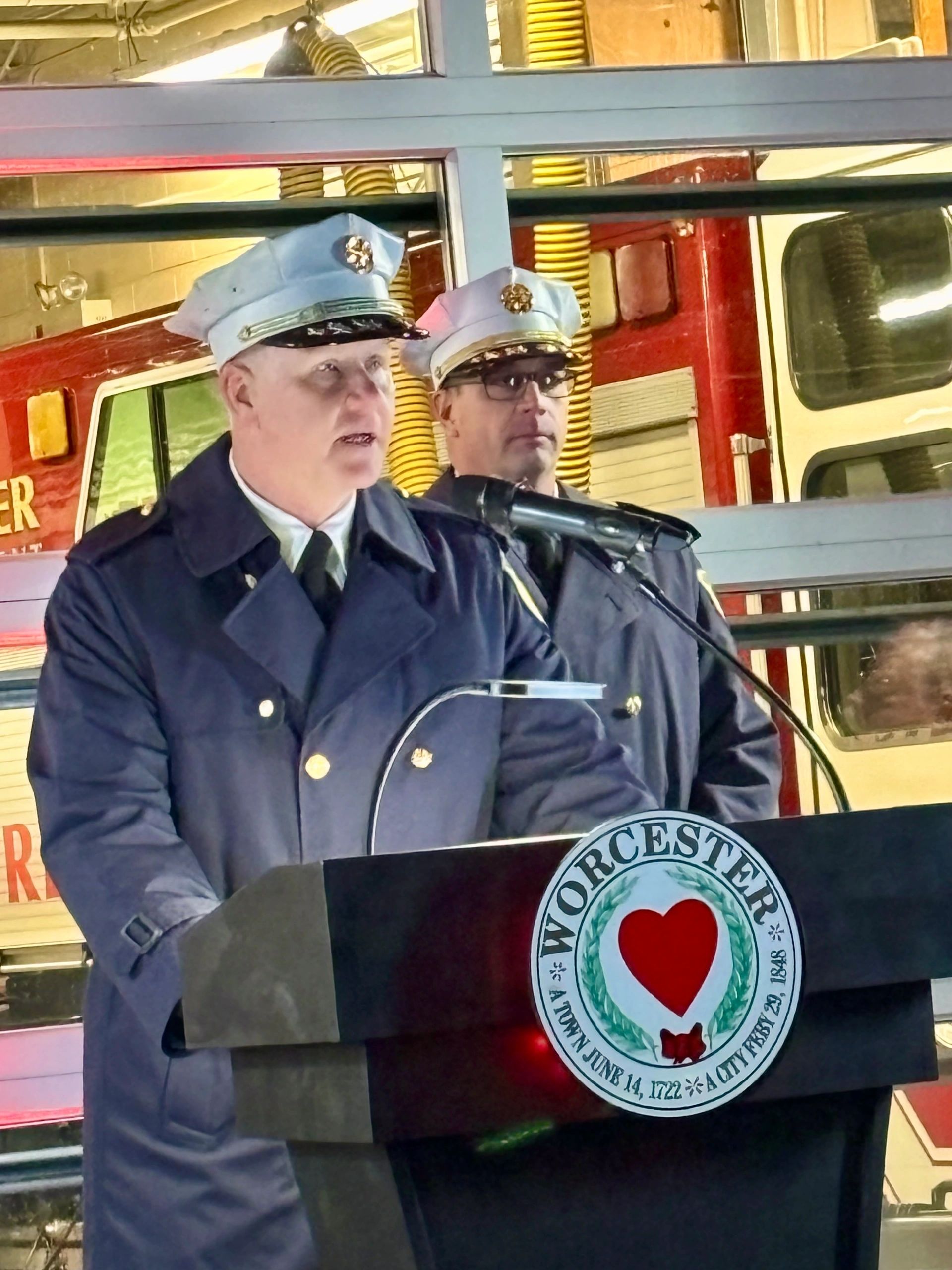 Fire chief Martin Dyer speaks at the memorial ceremony. Assistant fire chief Adam Roche is behind him (photo by Bill Doyle)