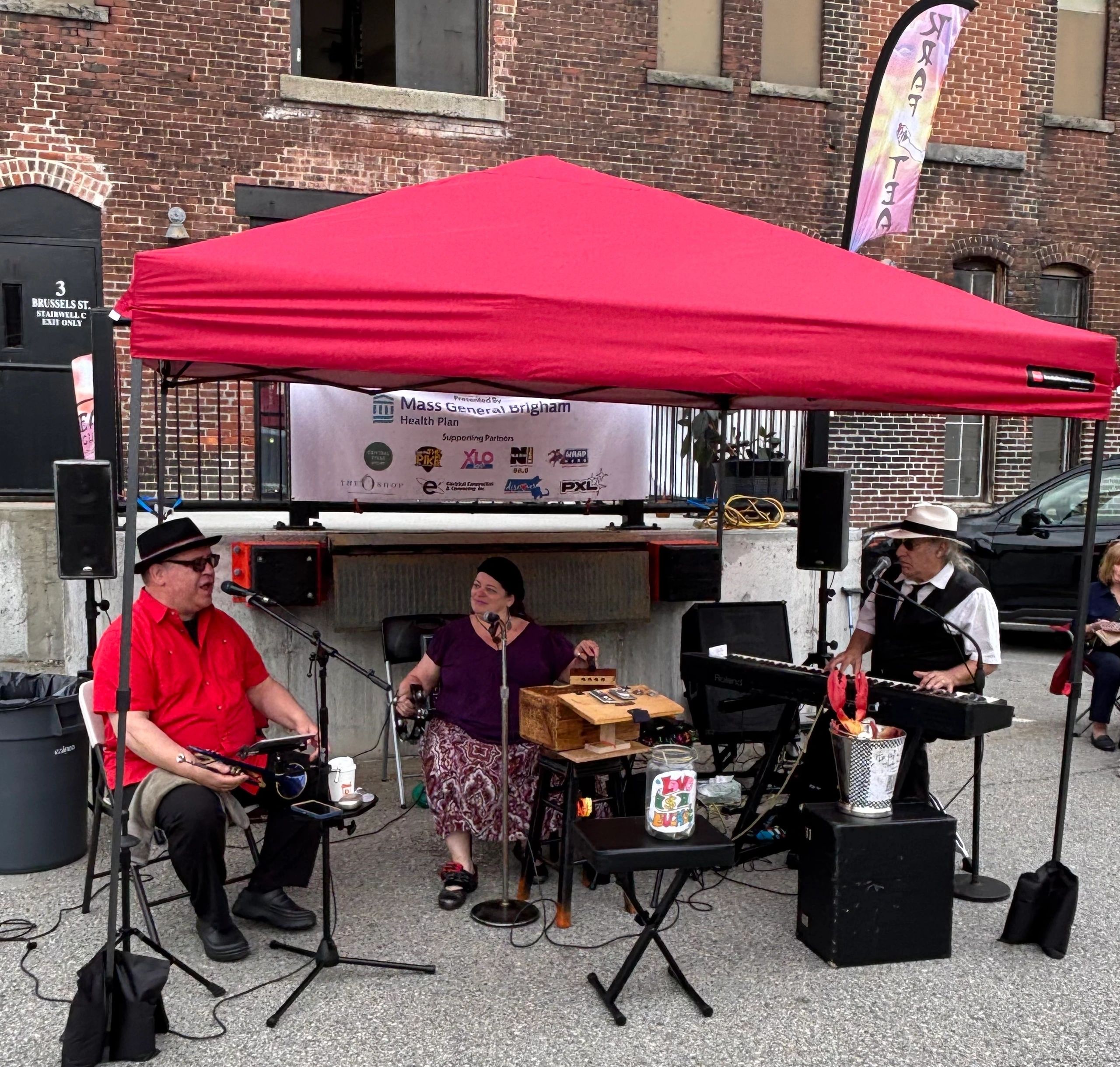 From left, Johnny “Blue Horn” Moriconi, Lisa Marie and Johnny Juno perform at Market on Brussels (photo by Bill Doyle)