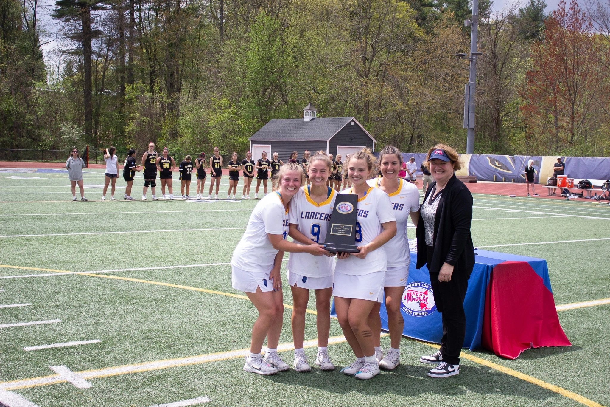 From left, Worcester State senior co-captains Ashley Hurley, Ava Gesner, Hannah Erickson, and Emma Grande with MASCAC Commissioner Angela Baumann (photo by Krystyanna Ramsdell)