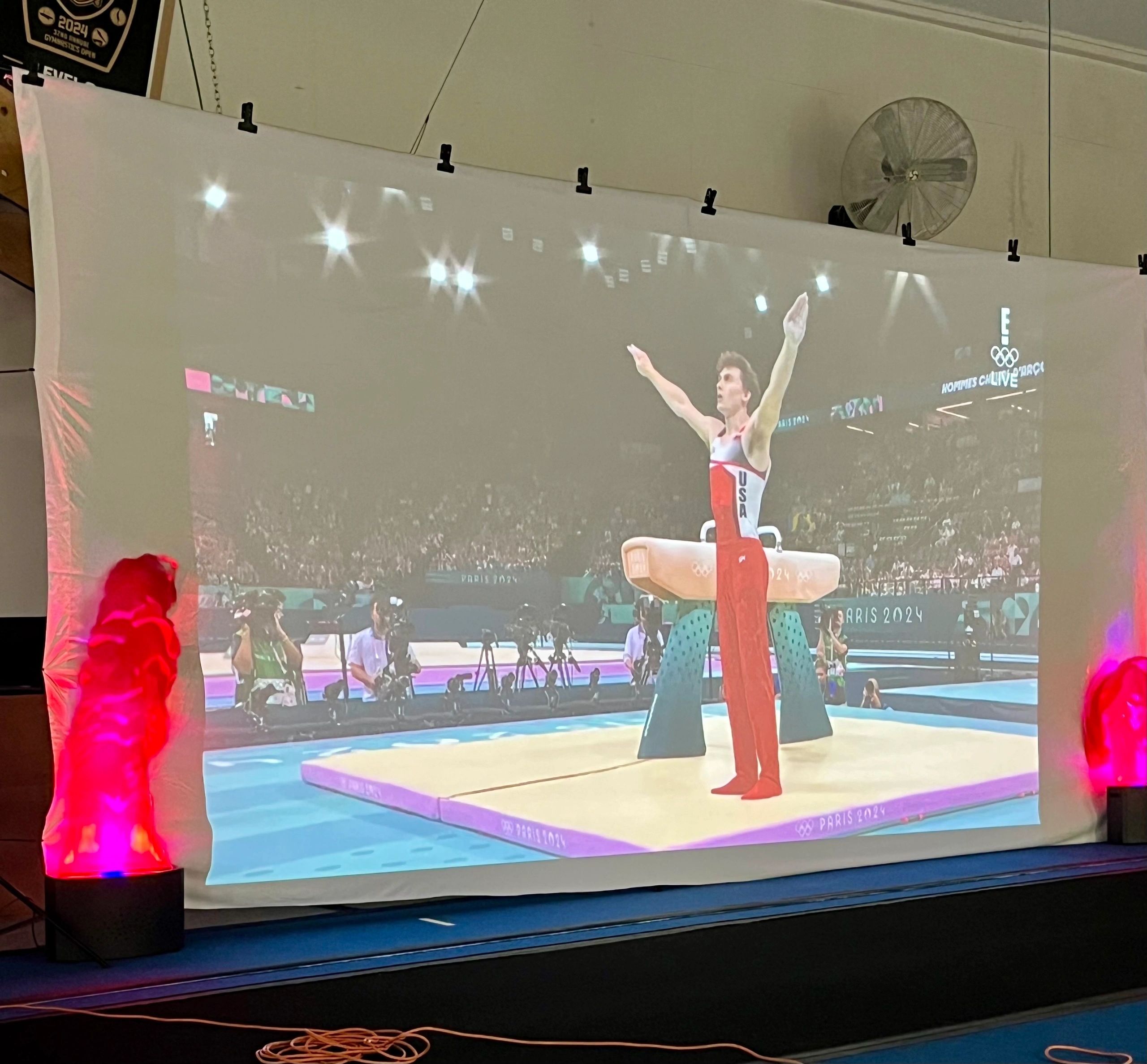 The video of Stephen Nedoroscik celebrating his bronze medal is projected onto a screen at the Sterling Academy of Gymnastics. (Mike Vigneux photo)