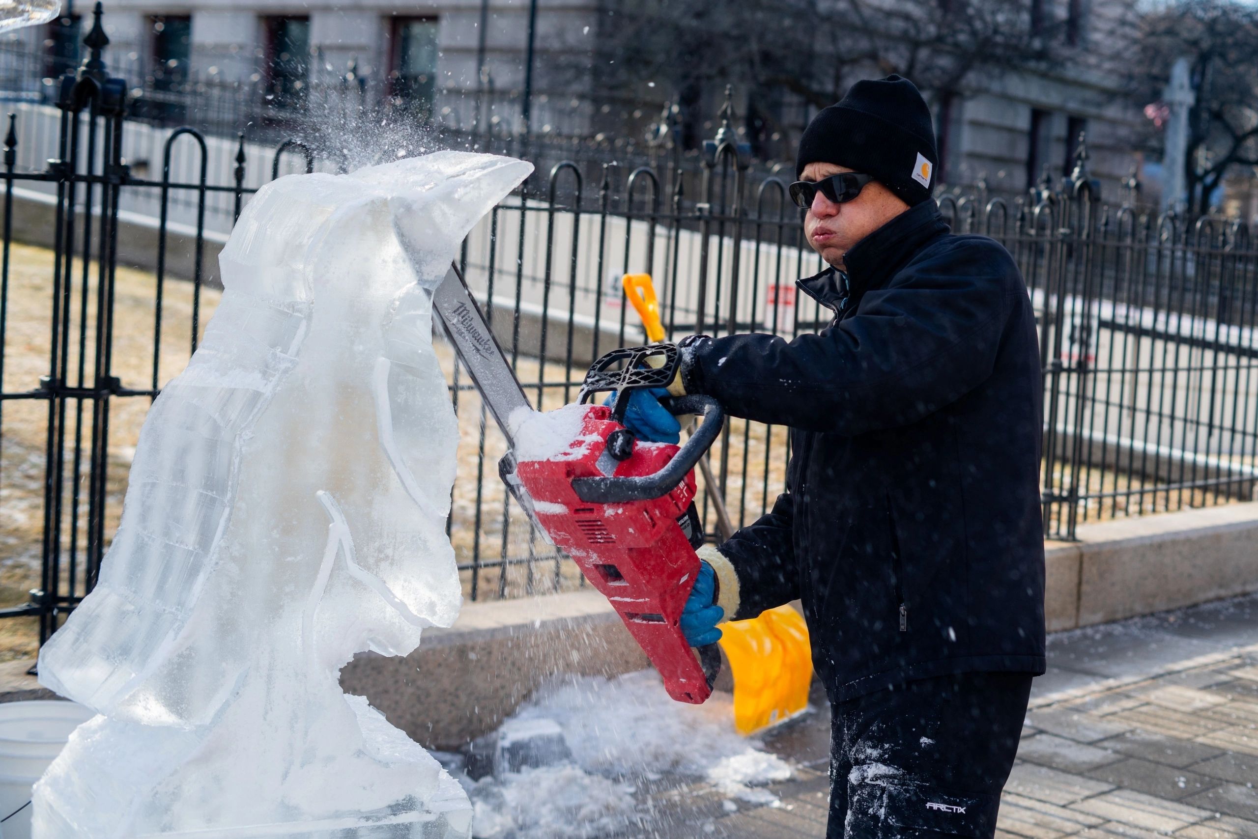 Donald Chappelle of Brilliant Ice Sculpture uses a chainsaw to carve a penguin statue. (photo by Steve Smith)
