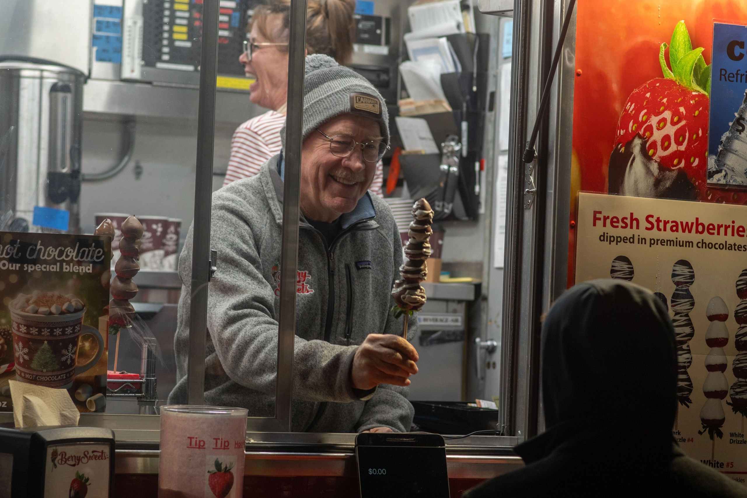 James Aulenback hands some hot chocolate to a young customer from the Berry Sweets truck (photo by Steve Smith)