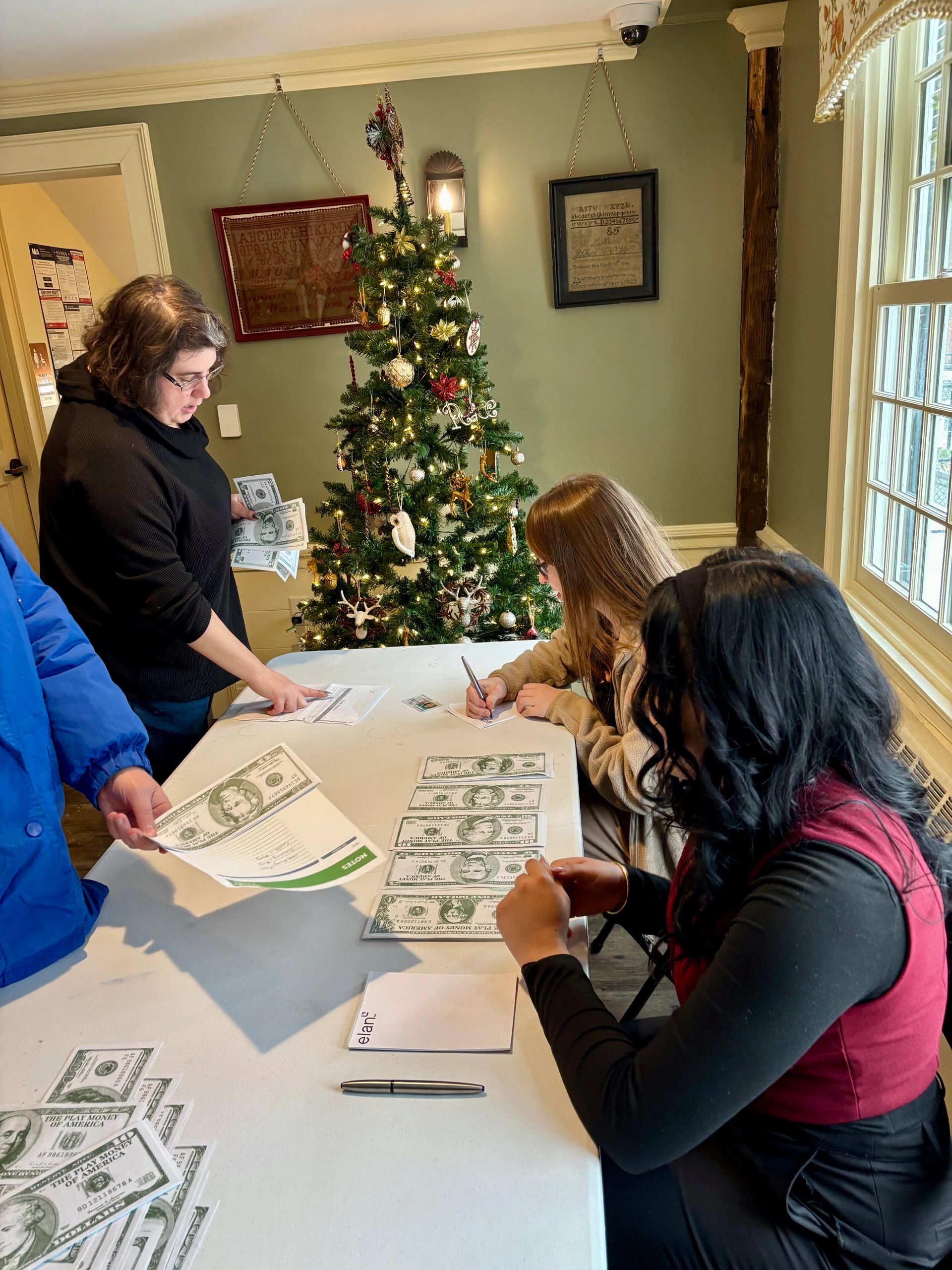 April Leblanc takes part in a mock teller experience with two Workers Credit Union tellers (photo by Bill Doyle)