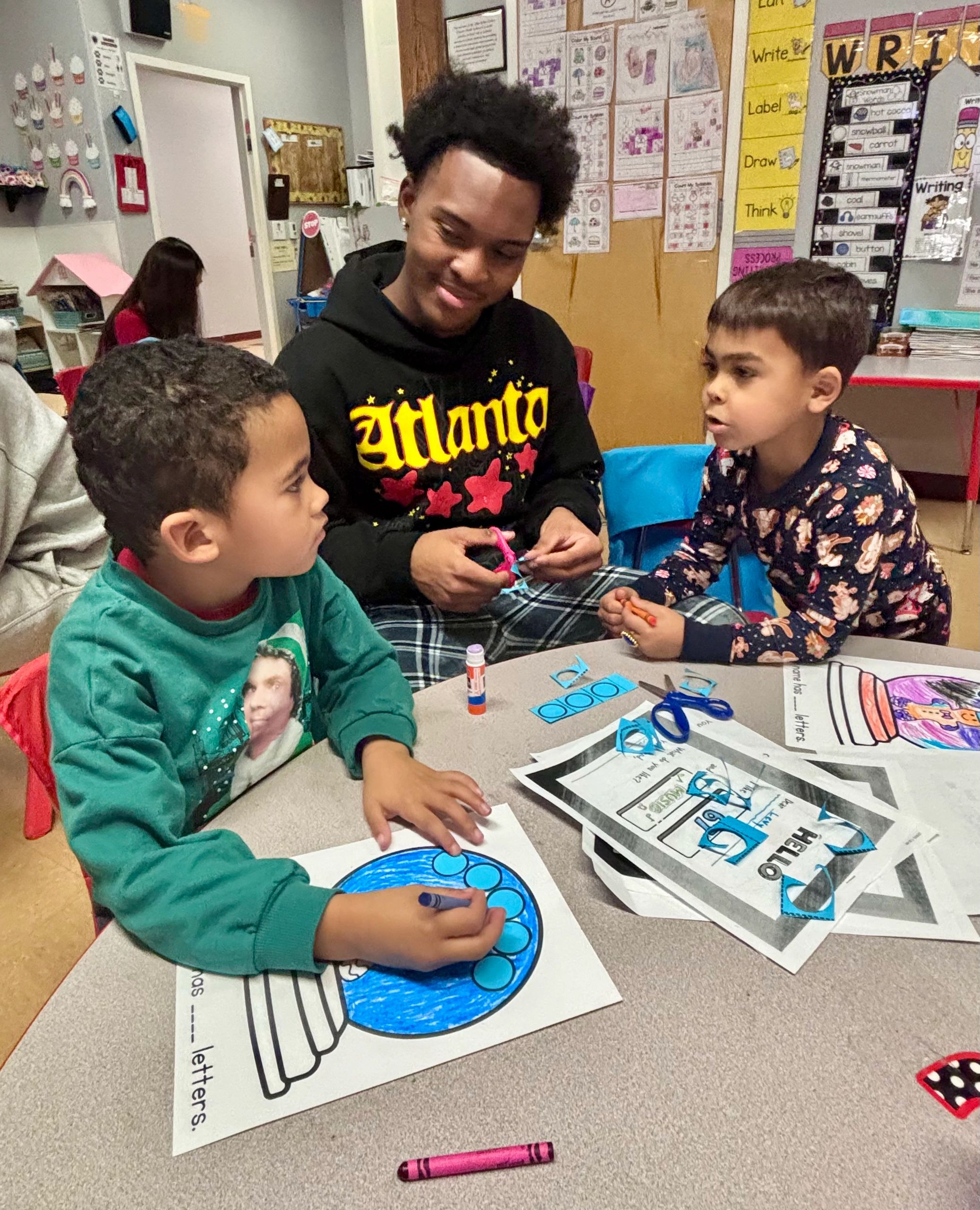 Senior Tristan Robinson bonds with kindergartners Daxton Canton (left) and Levy Fernandez at the Abby Kelley Foster Charter Public School (photo by Bill Doyle)