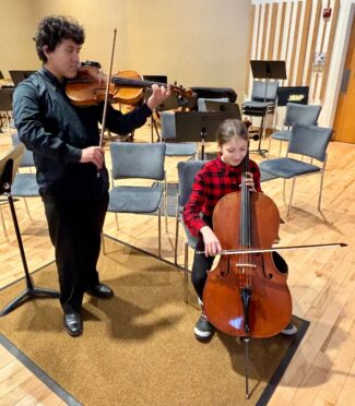 Diego Segura practices the viola and Sofia Hernandez-Williams warms up on the cello at the Shapiro Concert Hall at JOMP (photo by Bill Doyle)