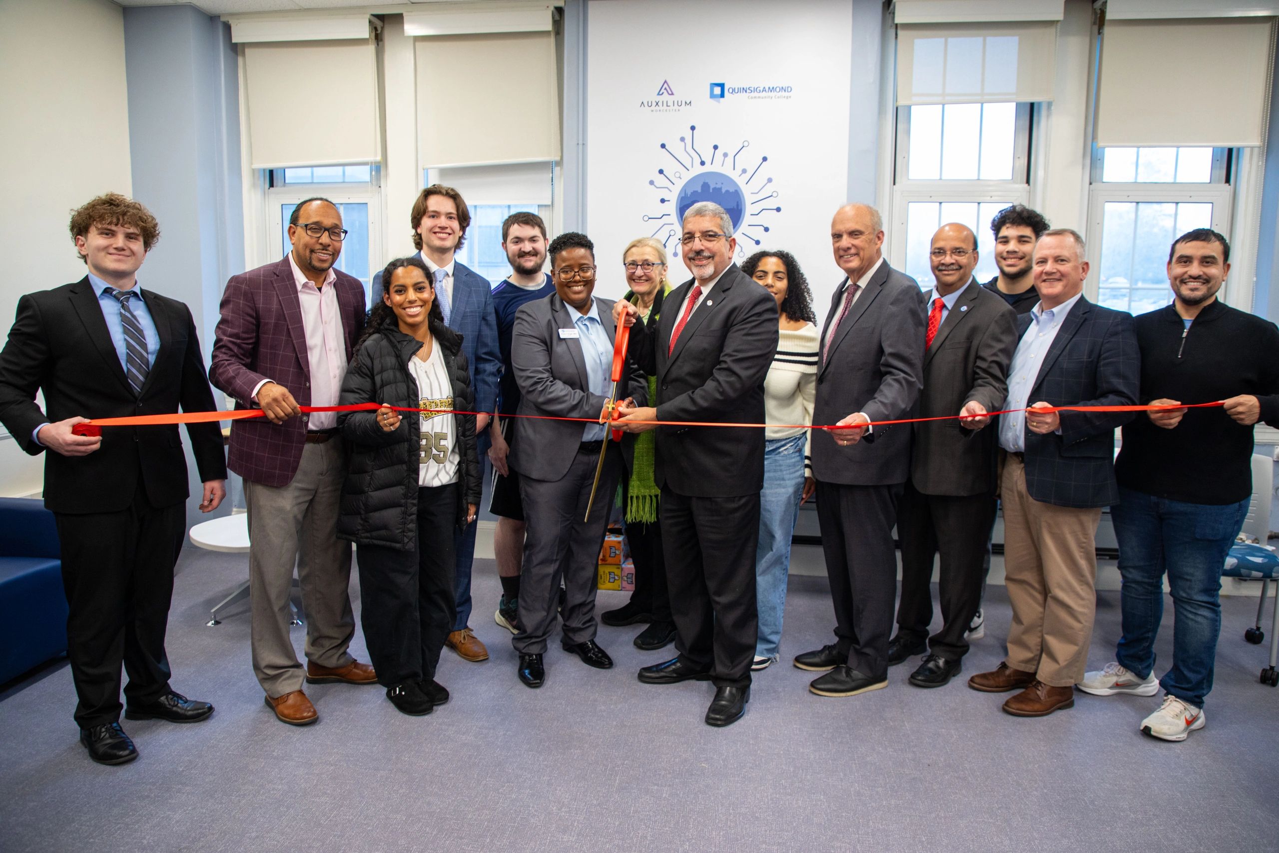 Director of the Auxilium Center for Entrepreneurship at QCC Rocky Knight and QCC President Dr. Luis Pedraja (center) cutting the ribbon with local officials