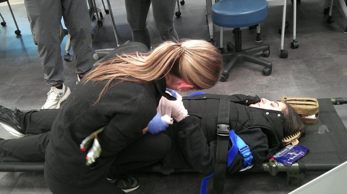 An Assumption University physician assistant student treats a simulated injury during a military-led trauma training exercise on campus (photo credit: Assumption University)