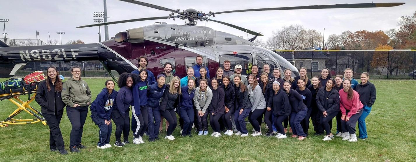 Assumption University physician assistant students gather near a medical helicopter after completing a Tactical Combat Casualty Care training exercise led by U.S. Army personnel (photo credit: Assumption College)