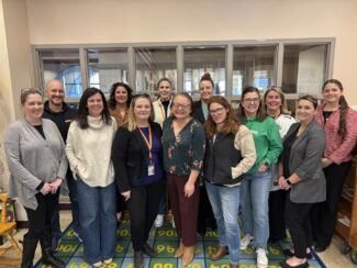 Participants of the Principal Mentor Group posed for a photo in the library of Quinsigamond Elementary School on Friday