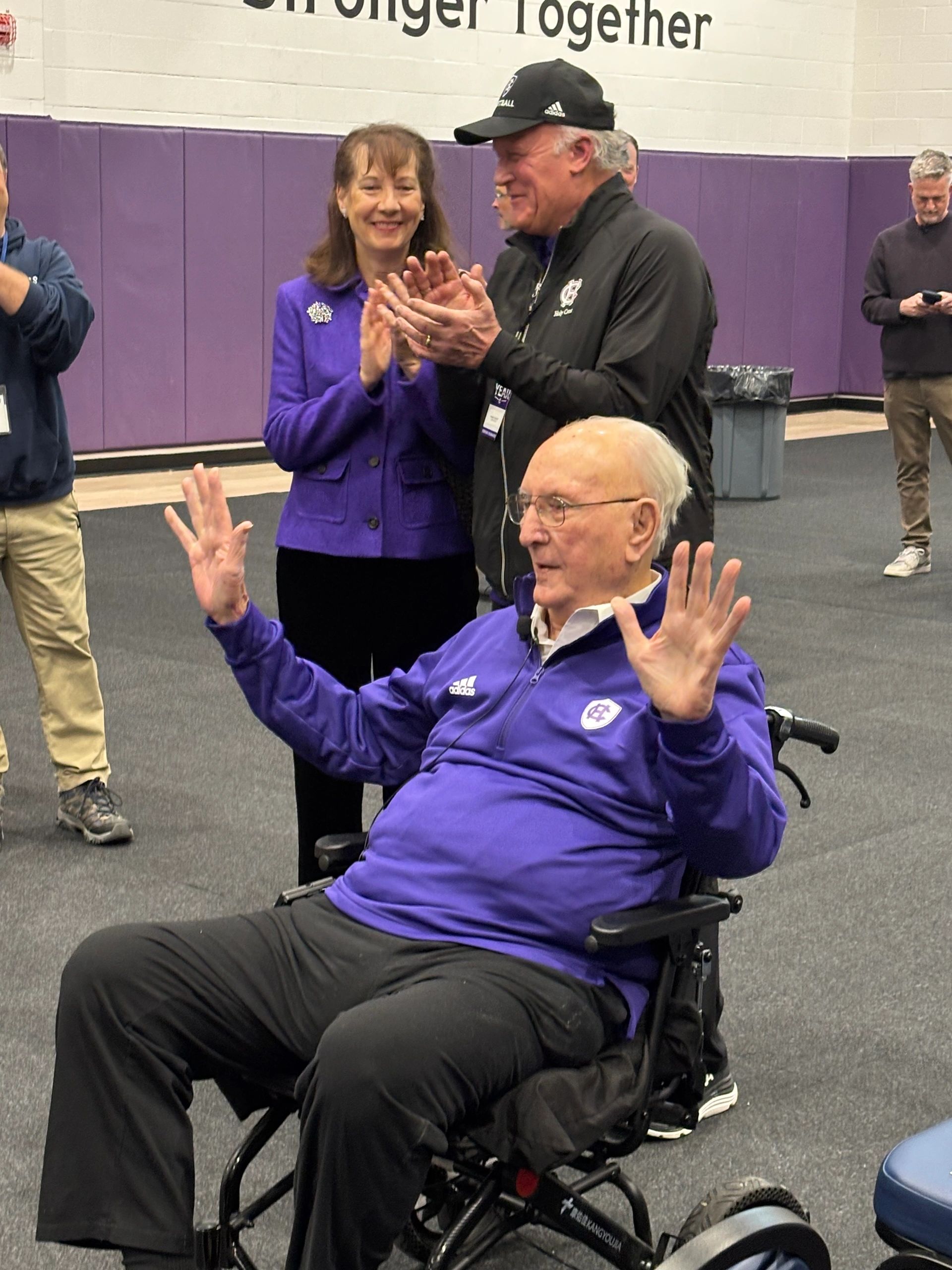 Bob Cousy arrives at the Blaney Gymnasium. His daughter Ticia Cousy, behind him, is among those who applaud. Photo by Bill Doyle